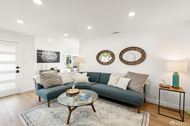 living area with light wood-style floors, recessed lighting, visible vents, and baseboards