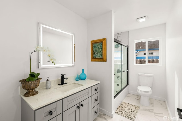 bathroom featuring toilet, bath / shower combo with glass door, vanity, baseboards, and marble finish floor