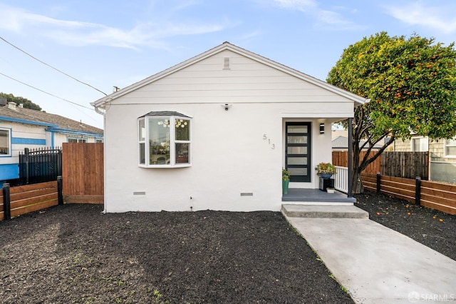 bungalow-style home featuring crawl space, fence, and stucco siding