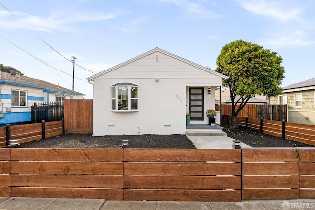 view of front of house with crawl space, a fenced front yard, and stucco siding