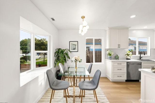 dining room with a notable chandelier, light wood finished floors, and recessed lighting