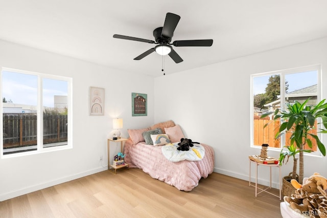 bedroom featuring light wood finished floors, baseboards, and a ceiling fan