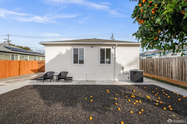 back of property with cooling unit, a fenced backyard, a patio, and stucco siding