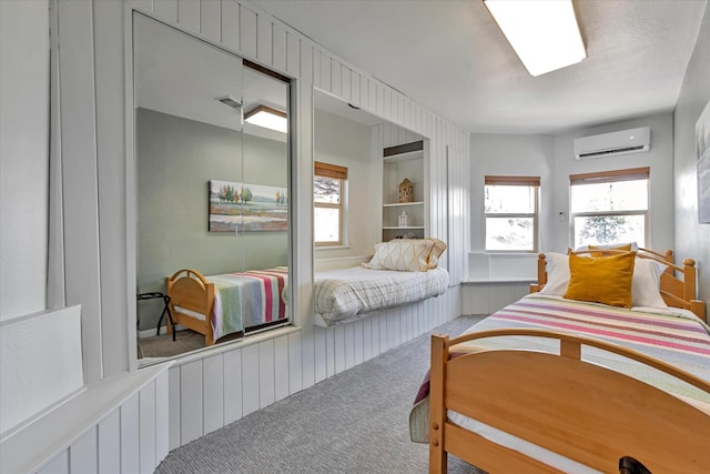 bedroom featuring a wall mounted AC, carpet floors, and multiple windows