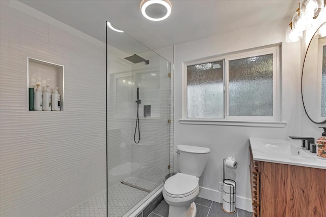 bathroom with tiled shower, vanity, tile patterned floors, and toilet