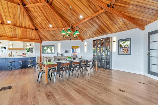 dining space featuring wooden ceiling, high vaulted ceiling, a notable chandelier, plenty of natural light, and light hardwood / wood-style floors