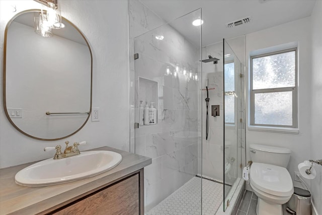 bathroom with vanity, toilet, and tiled shower