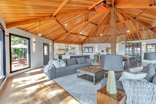 living room with light hardwood / wood-style flooring, high vaulted ceiling, and wooden ceiling