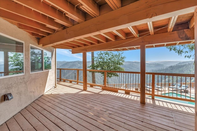 wooden deck featuring a mountain view and a pool