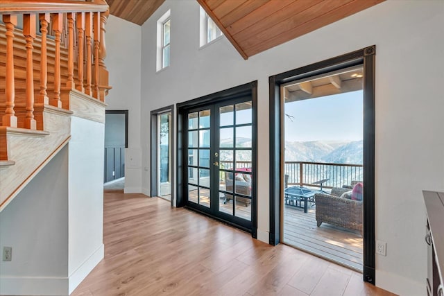 interior space featuring a mountain view, light wood-type flooring, wooden ceiling, and french doors