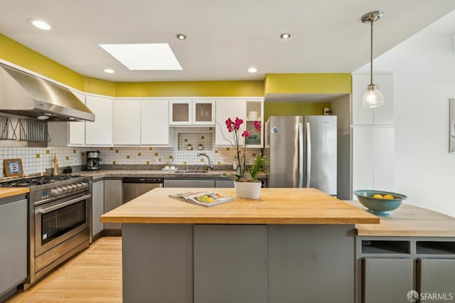 kitchen with butcher block countertops, hanging light fixtures, gray cabinets, stainless steel appliances, and white cabinets