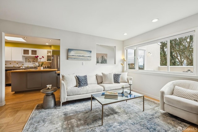 living room featuring a skylight and light parquet floors