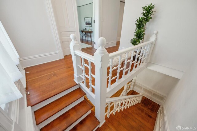 stairway with baseboards and wood finished floors