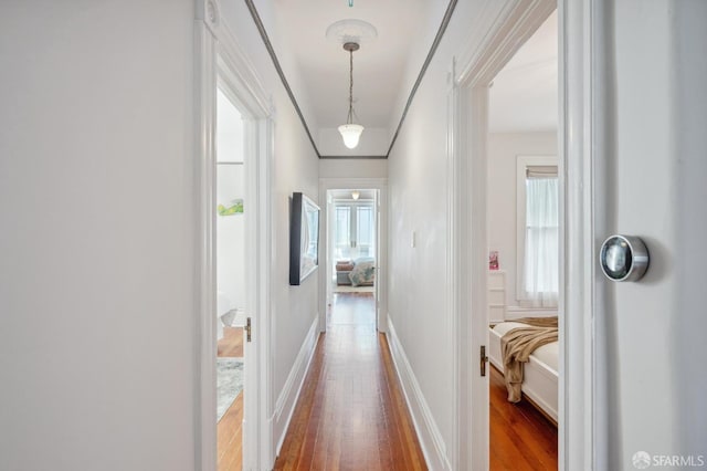 hall featuring wood finished floors and baseboards