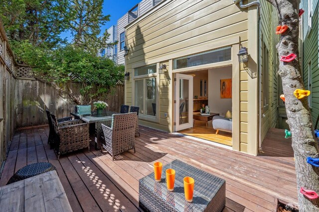 wooden terrace featuring outdoor dining space and fence