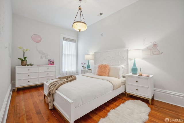 bedroom with visible vents, baseboards, and hardwood / wood-style floors