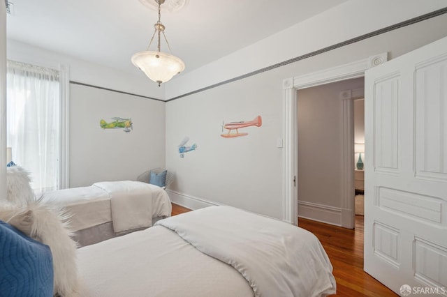 bedroom with baseboards and wood finished floors