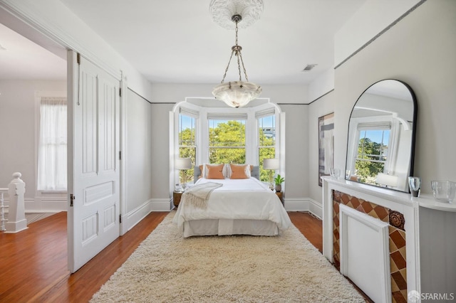 bedroom featuring visible vents, baseboards, and dark wood-style flooring