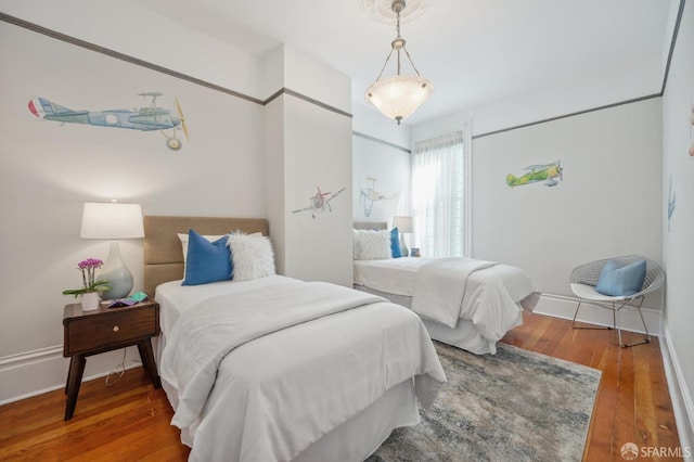 bedroom with baseboards and hardwood / wood-style flooring