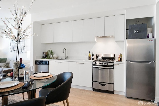 kitchen featuring light hardwood / wood-style flooring, white cabinetry, appliances with stainless steel finishes, and sink