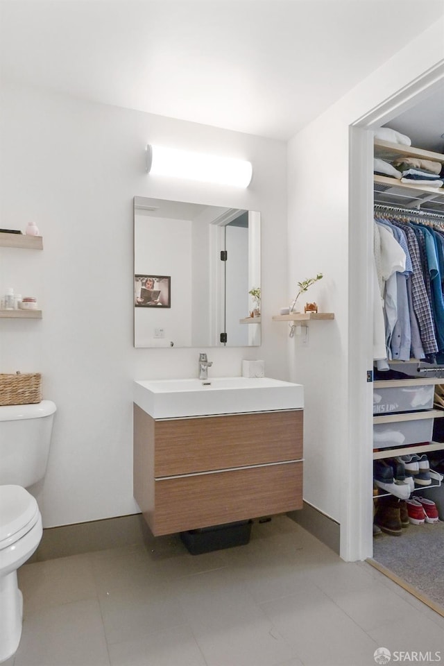 bathroom with vanity, tile patterned flooring, and toilet