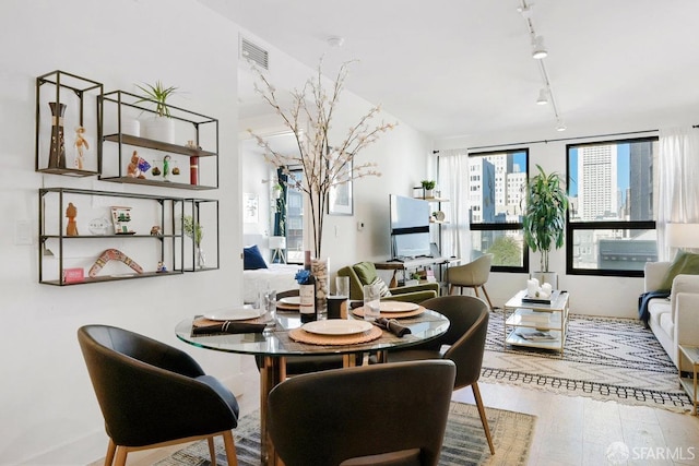 dining space featuring track lighting and hardwood / wood-style floors