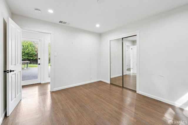 unfurnished room featuring visible vents, baseboards, wood finished floors, and recessed lighting