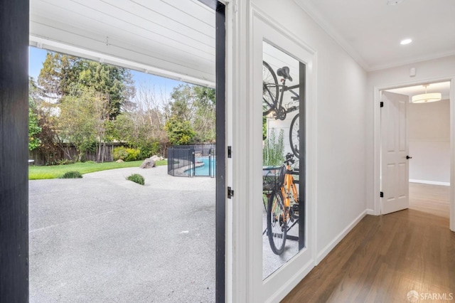 entryway with recessed lighting, dark wood-style flooring, baseboards, a wealth of natural light, and crown molding