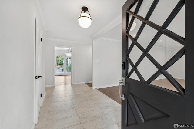 foyer with baseboards, marble finish floor, and crown molding