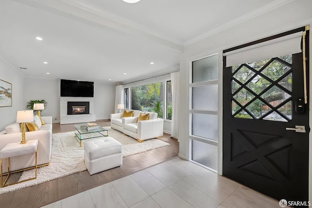 living room featuring baseboards, recessed lighting, a brick fireplace, and crown molding