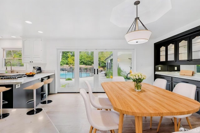 dining area with light wood-style flooring, french doors, and recessed lighting