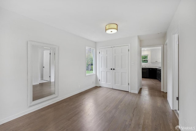 interior space with dark wood-type flooring and baseboards