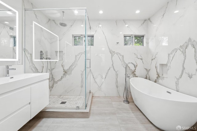 full bath featuring a soaking tub, a marble finish shower, vanity, and recessed lighting