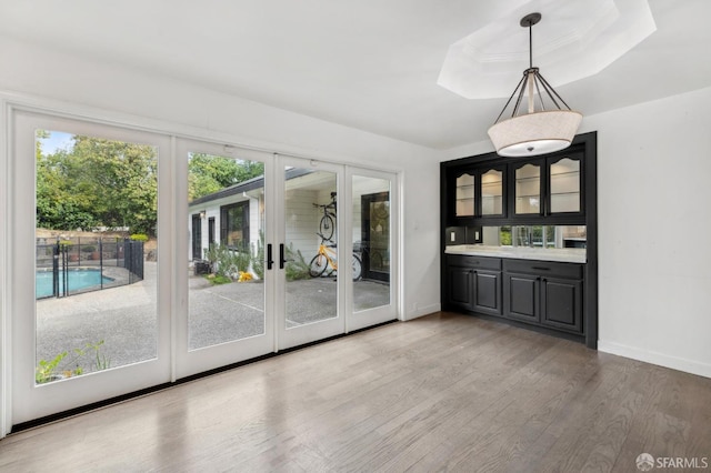 interior space with a raised ceiling, baseboards, and light wood finished floors