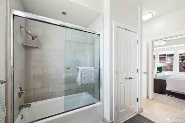 bathroom with tile patterned floors and shower / bath combination with glass door