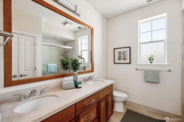 bathroom featuring a shower with shower door, tile patterned floors, vanity, and toilet