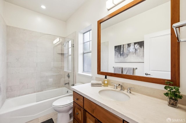 full bathroom with toilet, tiled shower / bath, tile patterned floors, and vanity