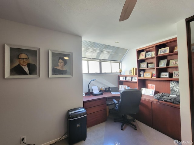 carpeted office space featuring a textured ceiling and ceiling fan