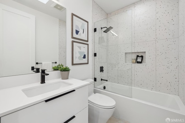 full bathroom with tiled shower / bath combo, vanity, and toilet