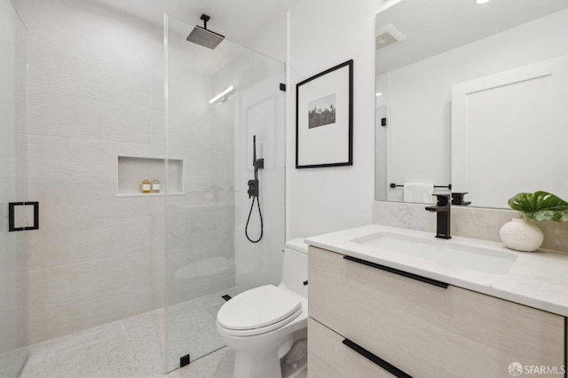 bathroom with a shower with shower door, toilet, and vanity