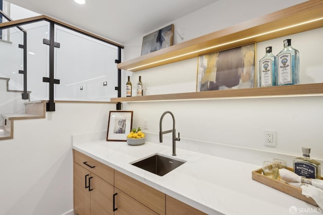 bar with sink and light stone countertops