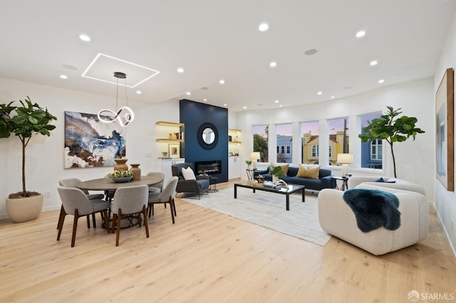 living room with a fireplace and light wood-type flooring