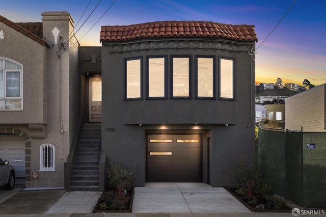 view of front of home with elevator and a garage