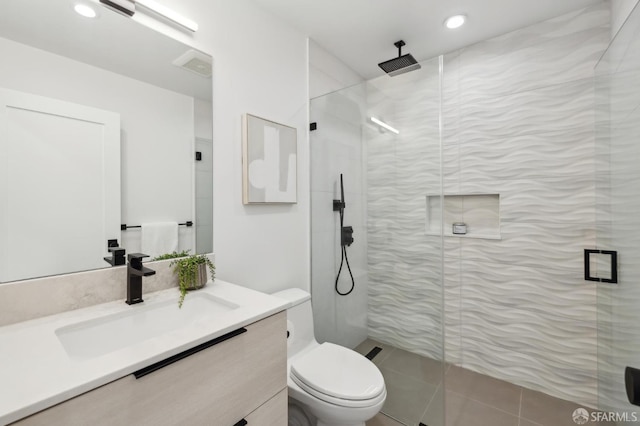 bathroom featuring an enclosed shower, vanity, and toilet