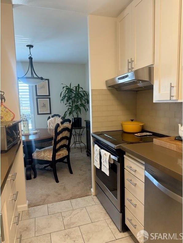 800 N Delaware St Unit 316, San Mateo, CA 94401 - kitchen with under cabinet range hood, stainless steel appliances, light colored carpet, and white cabinets