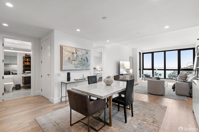 dining room with light wood-type flooring and recessed lighting