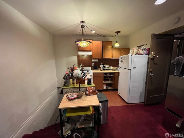 kitchen with white appliances and hanging light fixtures