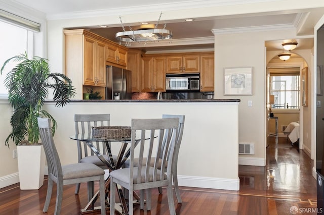 dining area featuring ornamental molding, dark hardwood / wood-style flooring, and plenty of natural light