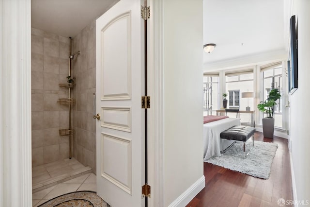 bathroom featuring hardwood / wood-style floors and tiled shower