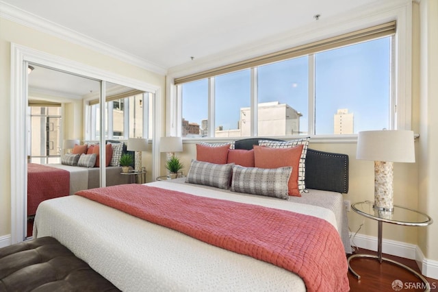 bedroom with ornamental molding, a closet, multiple windows, and hardwood / wood-style floors